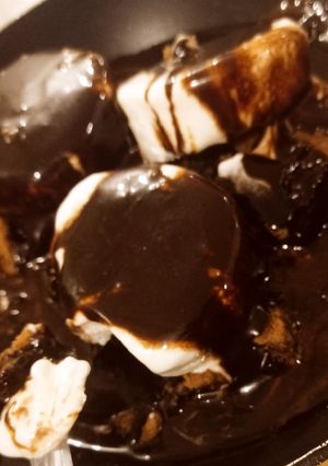 A picture of Flourless brownies with mexican chocolate sauce and Ice cream.
