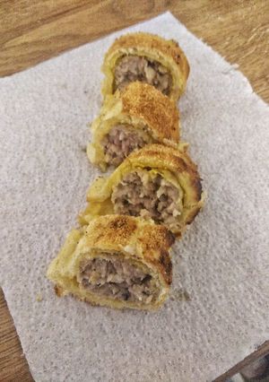 A picture of Sausage roll with mustard.
