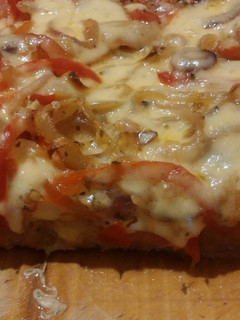 Una foto de Pizza integral con muzzarella, sin salsa (con mucha cebolla, morrón y tomate)