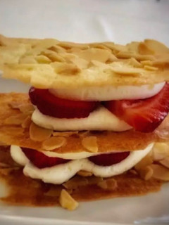 Una foto de Milhoja en coca de vidre con nata y fresas