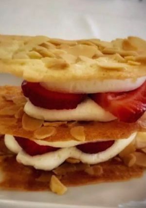 Una foto de Milhoja en coca de vidre con nata y fresas