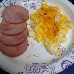 A picture of Canadian bacon with cheesy eggs.