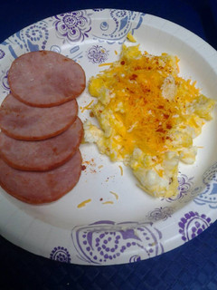 A picture of Canadian bacon with cheesy eggs.