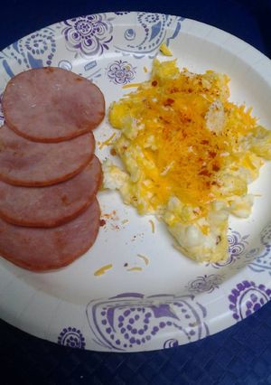 A picture of Canadian bacon with cheesy eggs.