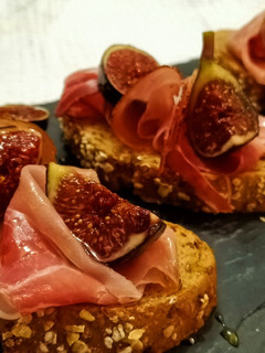 Una foto de Rebanadas de pan con jamón curado e higos frescos