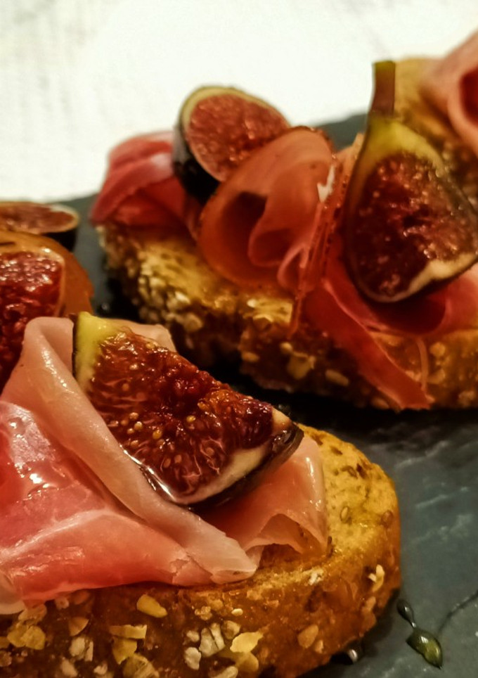Una foto de Rebanadas de pan con jamón curado e higos frescos