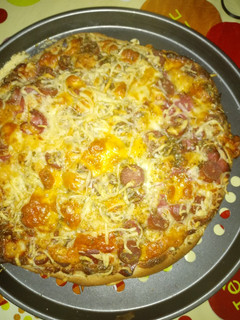 Una foto de Pizza con queso crema semi curado, salchichas y bacon