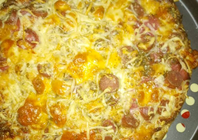 Pizza con queso crema semi curado, salchichas y bacon