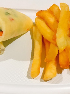A picture of Rolled vegetable omelette and potato fries.