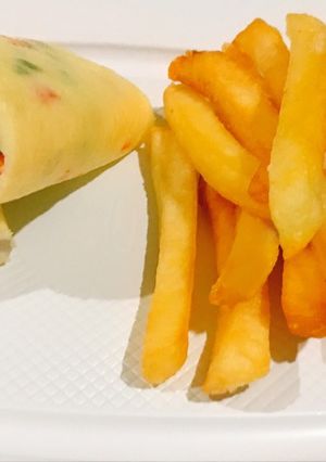 A picture of Rolled vegetable omelette and potato fries.