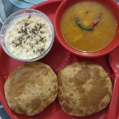 A picture of Aloo jhol, puri and raita.
