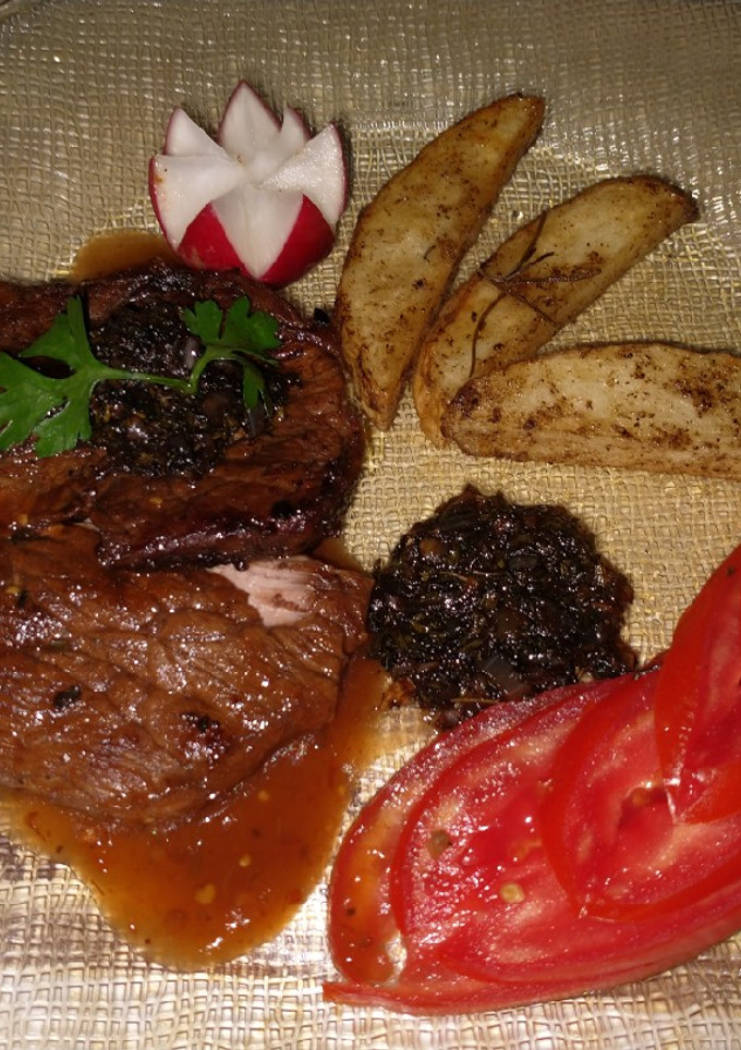Una foto de Filete al perejil con papas rústicas