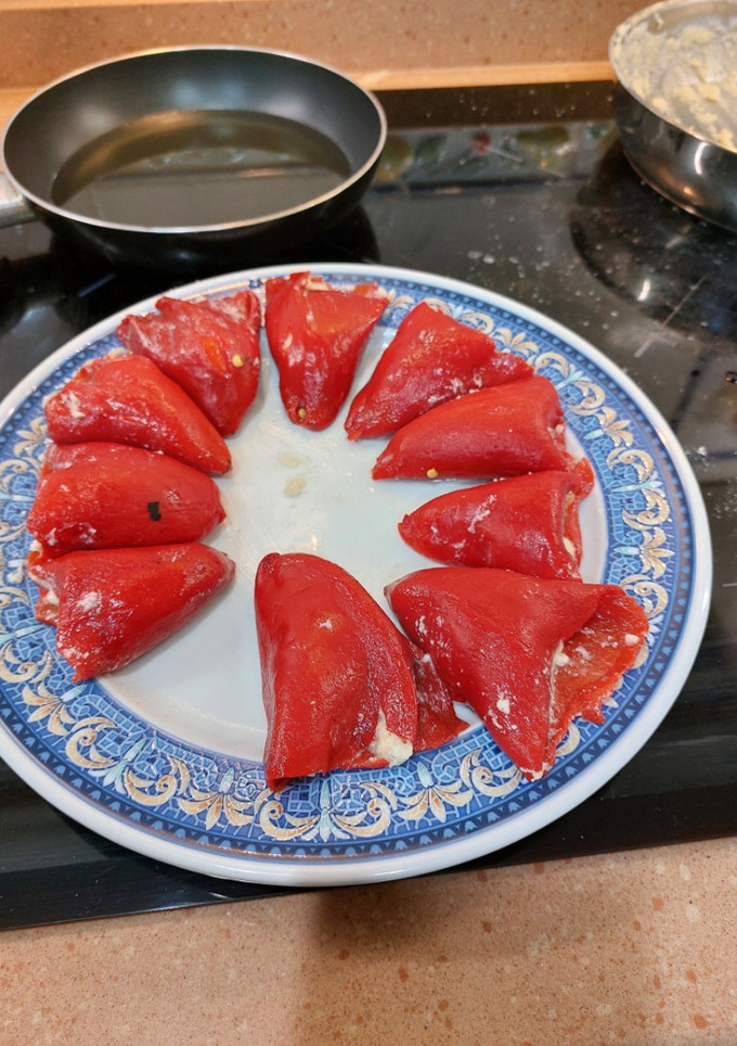 Una foto de Pimientos de piquillo rellenos de bacalao gambas con bechamel y salsa bilbaina
