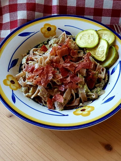 Foto di Tagliatelle colorate al pesto di zucchine e noci, con prosciutto croccante