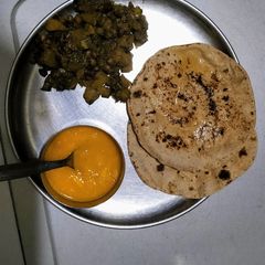 A picture of Kale chane and pumpkin sabji with roti and mango puree.