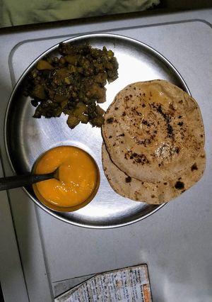 A picture of Kale chane and pumpkin sabji with roti and mango puree.