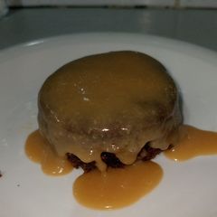 A picture of Dates pudding with sticky sauce.