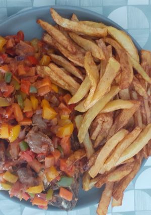 A picture of Potato chips and fried fish with peppered soup garnish with vegetables.