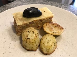 Una foto de Budín de zapallo italiano (zucchini) con parmesano gratinado y papas al eneldo