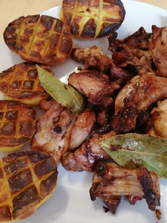 Una foto de Conejo con ajo y laurel acompañado de patatas asadas