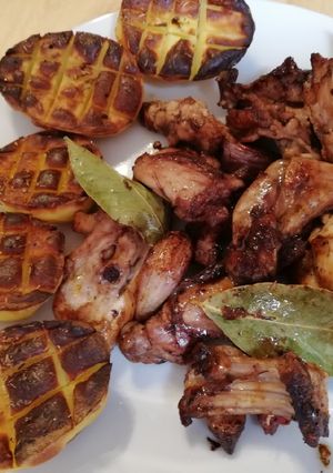 Una foto de Conejo con ajo y laurel acompañado de patatas asadas