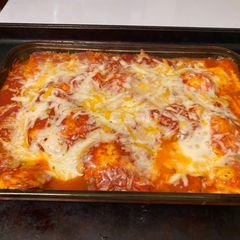 A picture of Bake ravioli with salad and cheesy bread.