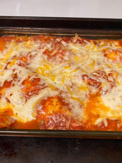 A picture of Bake ravioli with salad and cheesy bread.