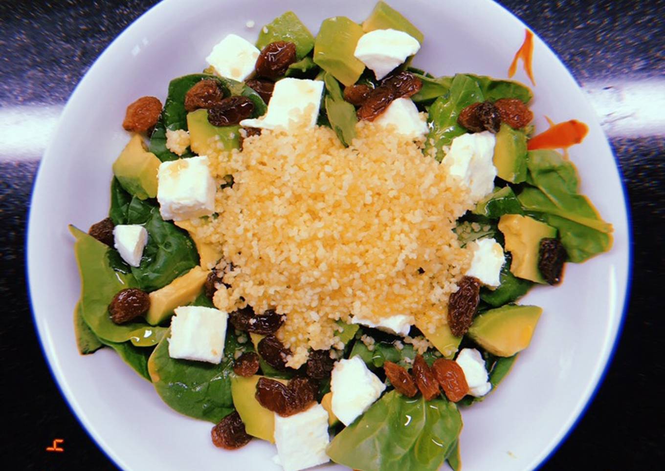 Ensalada de espinacas, cous-cous, aguacate, mozzarella y pasas