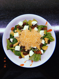 Una foto de Ensalada de espinacas, cous-cous, aguacate, mozzarella y pasas
