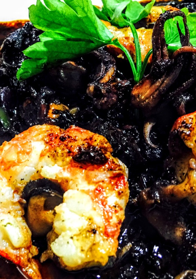 Una foto de Arroz negro integral con chipirones gambas vieyras y mejillones