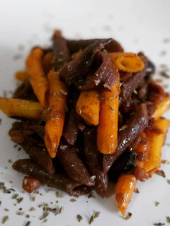Una foto de Penne de zanahorias sin gluten con salsa de anchoas y calamar