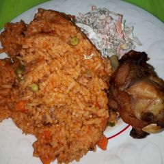 A picture of Jollof Rice, Chicken and Salad.