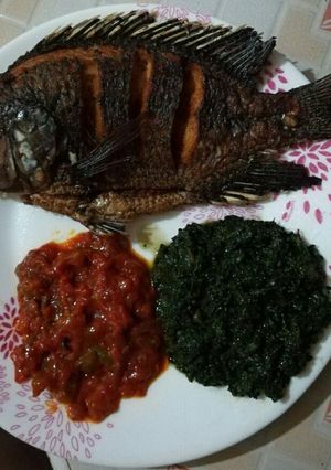 A picture of Fried Fish served with pumpkin leaves.