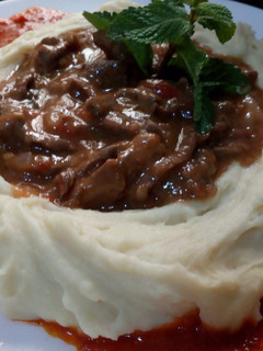 Una foto de Res en salsa con hummus de papas
