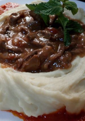 Una foto de Res en salsa con hummus de papas