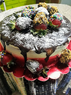 Una foto de Torta o pastel red velvet con ganache y frutillas