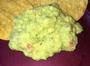 Una foto de guacamole con tomatitos