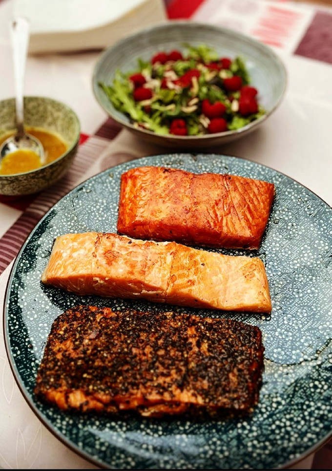 Una foto de Salmón con distintos aderezos y ensalada de rúcula y frambuesas con vinagreta de mostaza miel 🍯