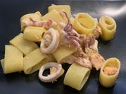 Una foto di pasta con frutti di mare calamarata
