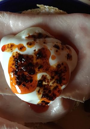 Una foto de Huevos Poché en bagel con jamón