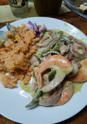 Una foto de Rajas de nopal con rajas de salchicha a la crema con queso con camaron y paella