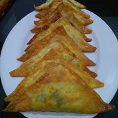 A picture of Pangsit goreng segitiga isi jagung manis dan daun bawang.