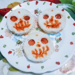 A picture of Halloween spooky bread sandwich with tomato sauce.