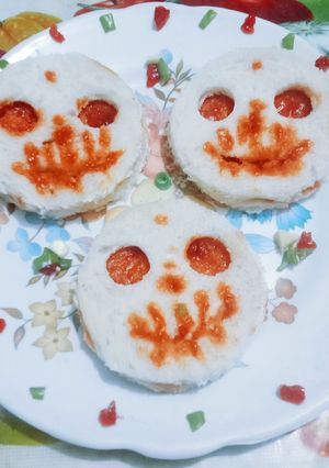 A picture of Halloween spooky bread sandwich with tomato sauce.