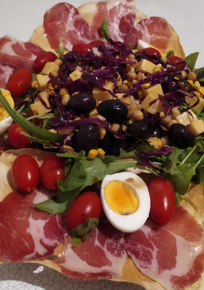 Una foto de Ensalada multicolor en cuna de pan