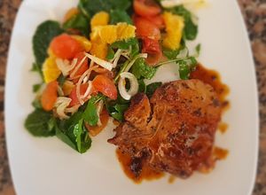 Una foto de Costilla de cerdo con naranja y ensalada de rúcula