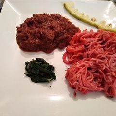 A picture of Braised liver with noodles and spinach.