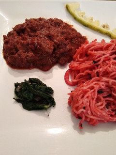 A picture of Braised liver with noodles and spinach.