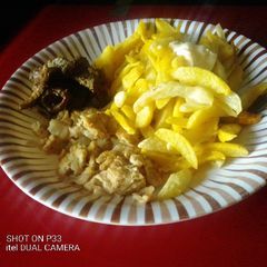 A picture of Fried chips and flavoured spiced egg.