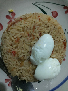 A picture of Jollof rice and boiled egg.